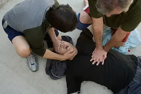 a-man-in-cardiac-arrest-is-being-given-CPR-by-another-man